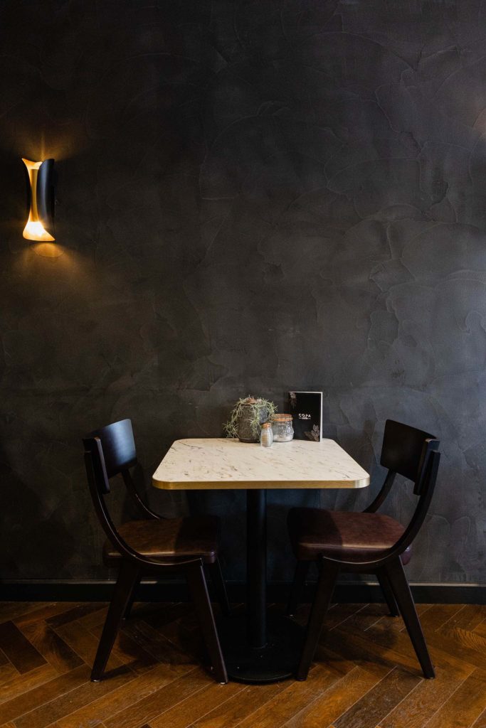 table and chairs against a dark grey wall