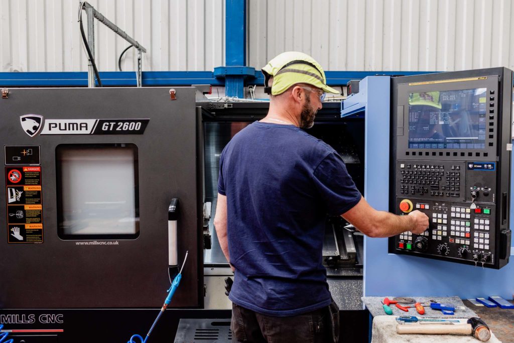 industrial worker in hard hat working a machine