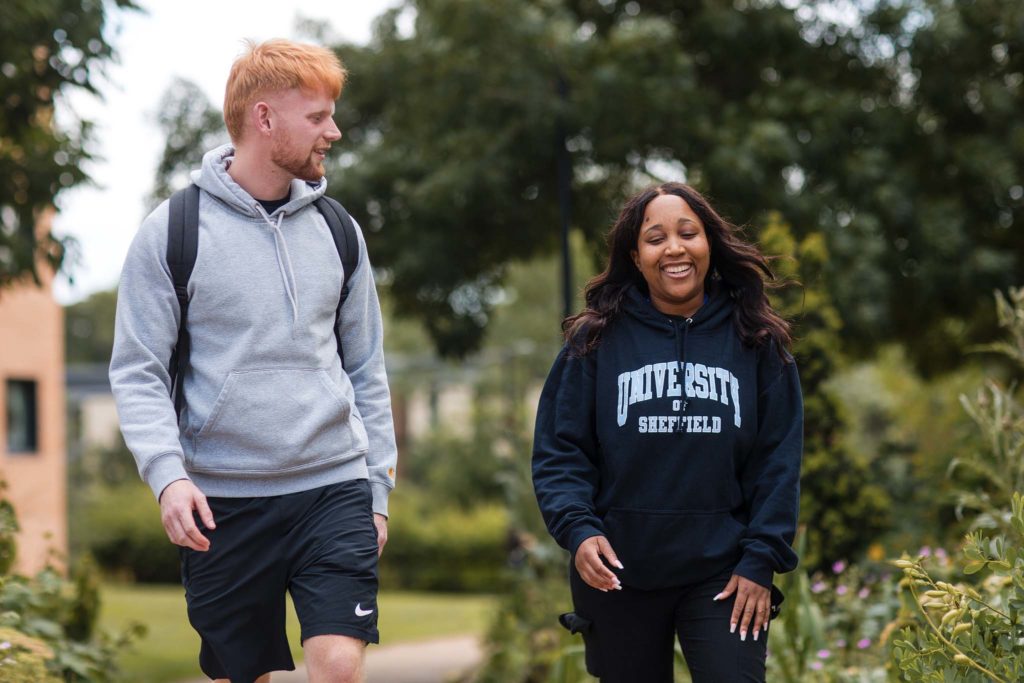 two Sheffield University students laughing whilst they walk